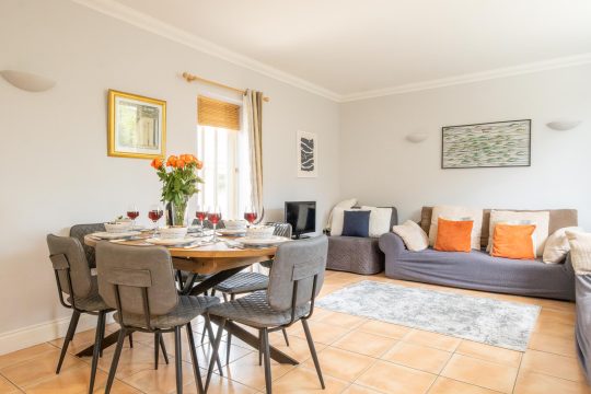 1 Hazelwood, three bedroom house in Friston - living and dining room with round table, grey sofa and tiled floor