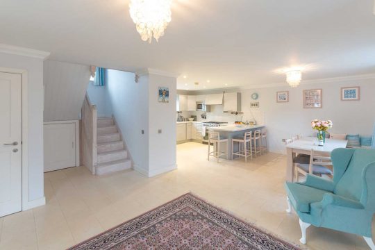 5 The Sanctuary, three bedroom house in Thorpeness - open-plan hallway with staircase, kitchen and breakfast bar