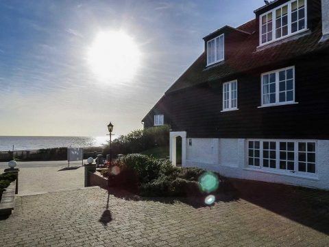 3 Ogilvie Lodge, two bedroom lodge in Thorpeness - black timber and white rendered exterior with the sea beyond