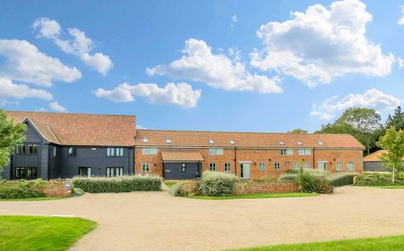 Sanderling, two bedroom property in Friston - black timber and red brick barn conversion exterior with gravel drive