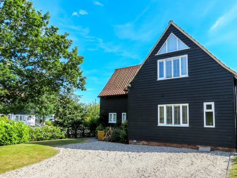 Meare House, Thorpeness - black weatherboarded house with red pantile roof and gravel drive