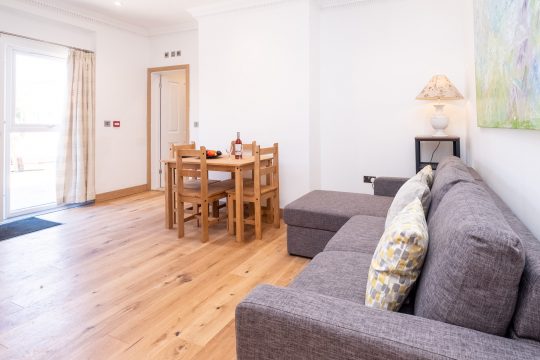 Birch, countryside apartment at Three Tuns, Pettistree - open plan living room with grey sofa and oak dining table