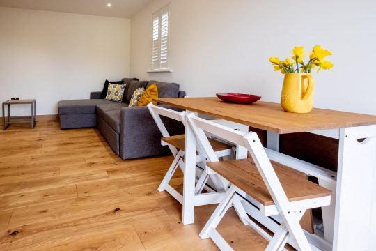 Oak, Three Tuns Apartments, Pettistree - open plan living area with corner sofa and folding dining table