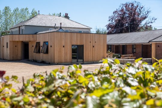 Ash, countryside apartment at Three Tuns, Pettistree - timber-clad apartment building and gravel courtyard