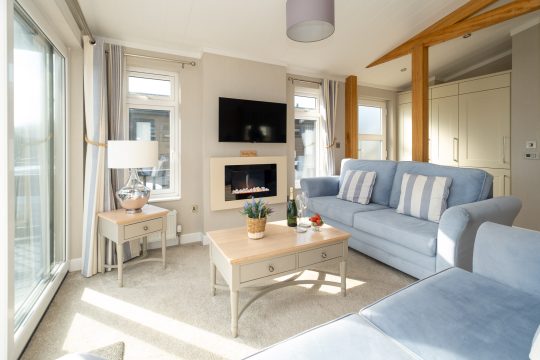 Hunky-Dory, three bedroom seaside house at Sizewell near Aldeburgh - lounge with blue sofas, electric fire and wall mounted television
