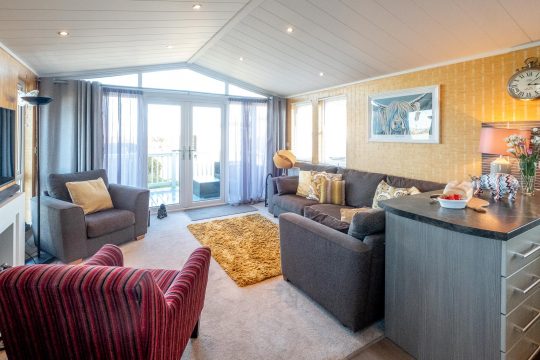 Chelsea Lodge, two bedroom lodge in Sizewell near Thorpeness - open plan lounge with sofas and doors onto the deck
