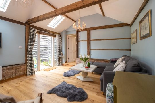 The Cart Lodge near Wickham Market - vaulted sitting room with exposed beams and doors to the garden
