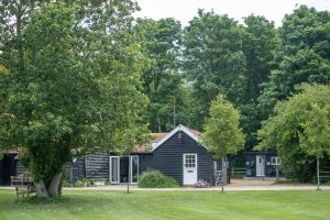 The Cart Lodge, one bedroom holiday lodge near Wickham Market - black timber exterior and garden