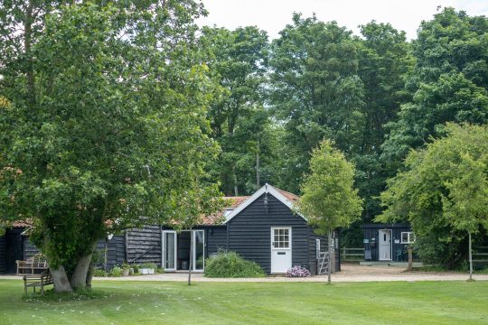 The Cart Lodge, one bedroom holiday lodge near Wickham Market - black timber exterior and garden