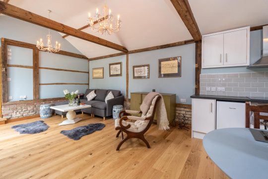 The Cart Lodge near Wickham Market - sitting area with sofa, chandeliers and kitchen
